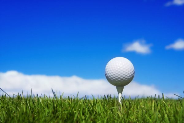 Golf ball teed up against blue sky